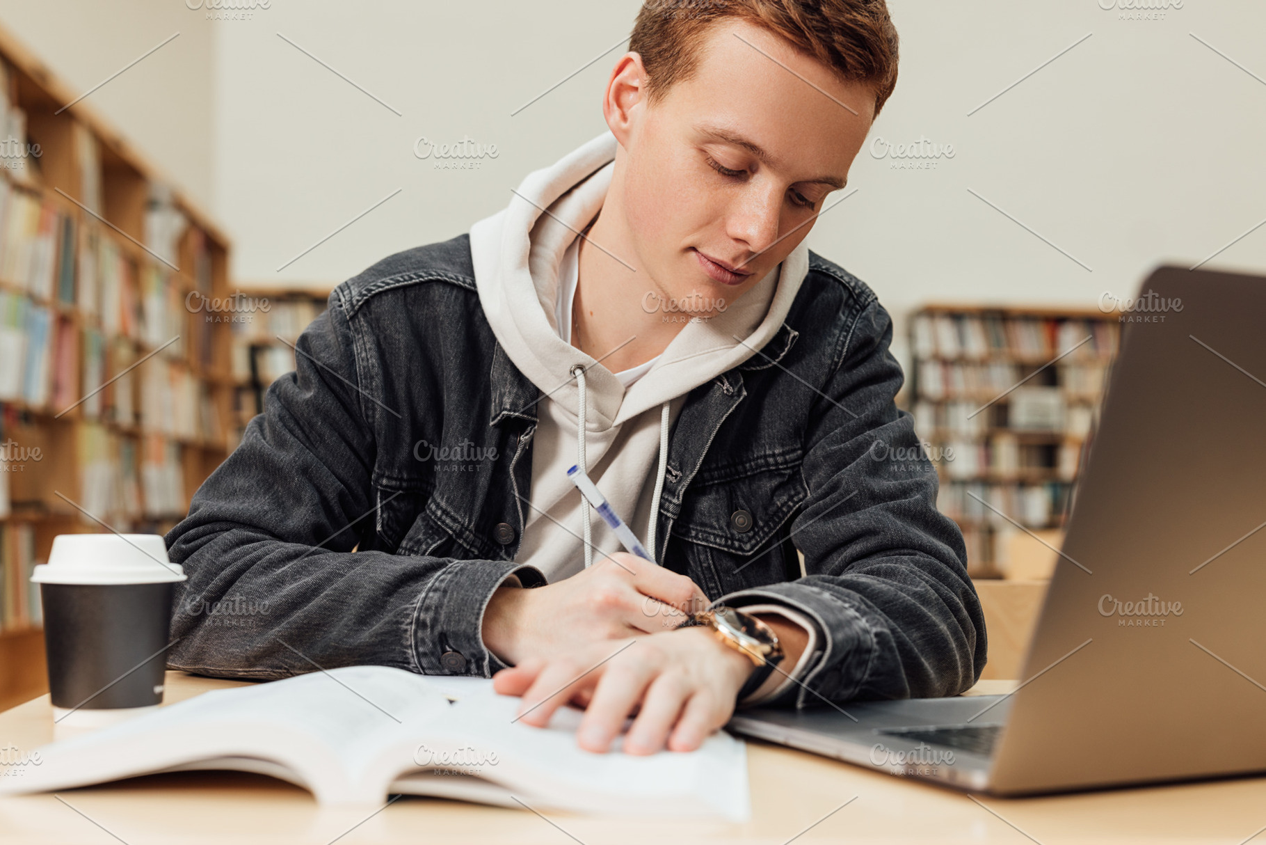 Male student in library writing, a Person Photo by Artem Varnitsin