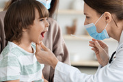 Professional woman pediatrician wearing protective face mask checking throat of, a Photo by Prostock-Studio (Thumbnail 2 of 2)