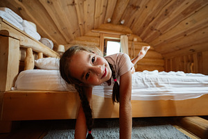 Young girl relaxing in a cozy log cabin with wooden interior decor, a Photo by AS photostudio