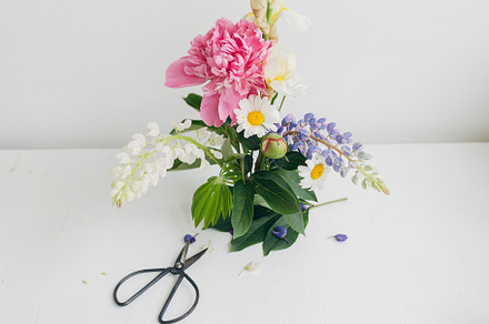 Modern summer flowers composition on rustic white table indoors., a Nature Photo by Sonjachni