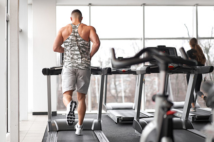 Muscular athletic bodybuilder fitness model running treadmill gym near big wind, a Sports & Recreation Photo by andreonegin market