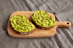 Homemade Avocado Toast with Salt and Pepper on a wooden board, s, a Food & Drink Photo by LiudmylaChuhunova