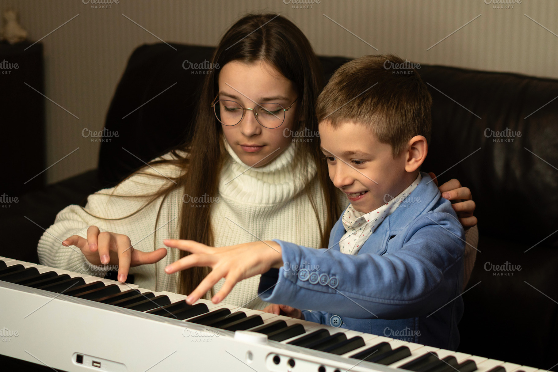 Young boy playing piano with kid, a School & Education Photo by Elena Vagengeim
