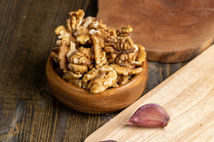 Peeled walnuts in a wooden bowl on the table, a Photo by MyPhotos