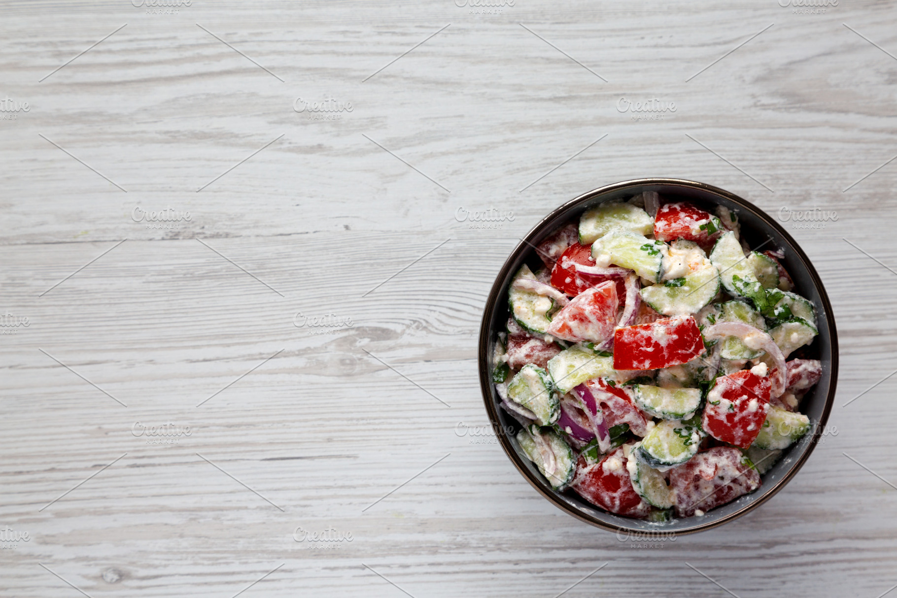 Homemade Tomato Cucumber Feta Salad in a Bowl, top view. Flat la, a Food & Drink Photo by LiudmylaChuhunova