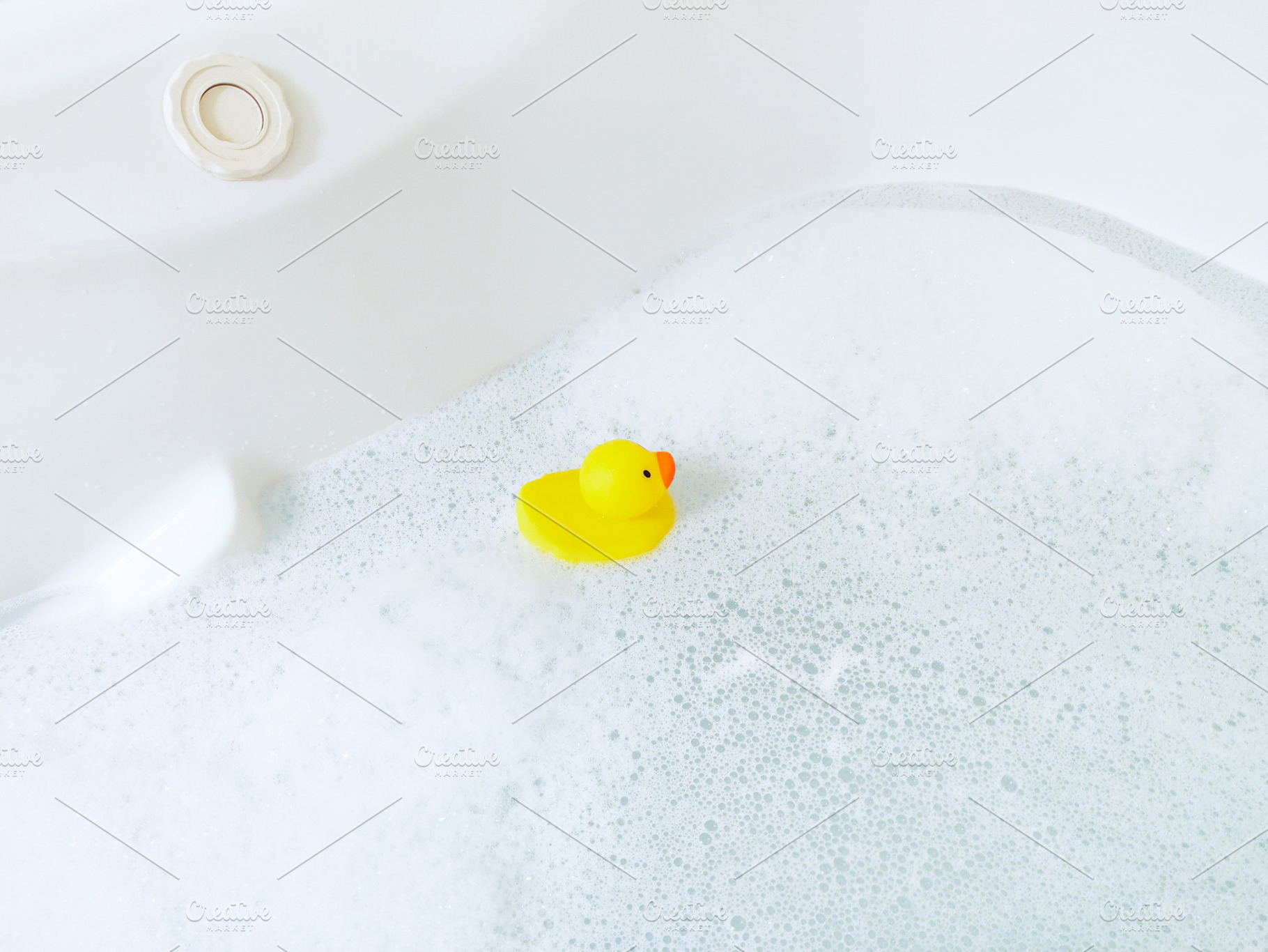 Bathtub with foam bubbles and yellow playful rubber duck in bubb, a Health & Medical Photo by Irina Moskalev