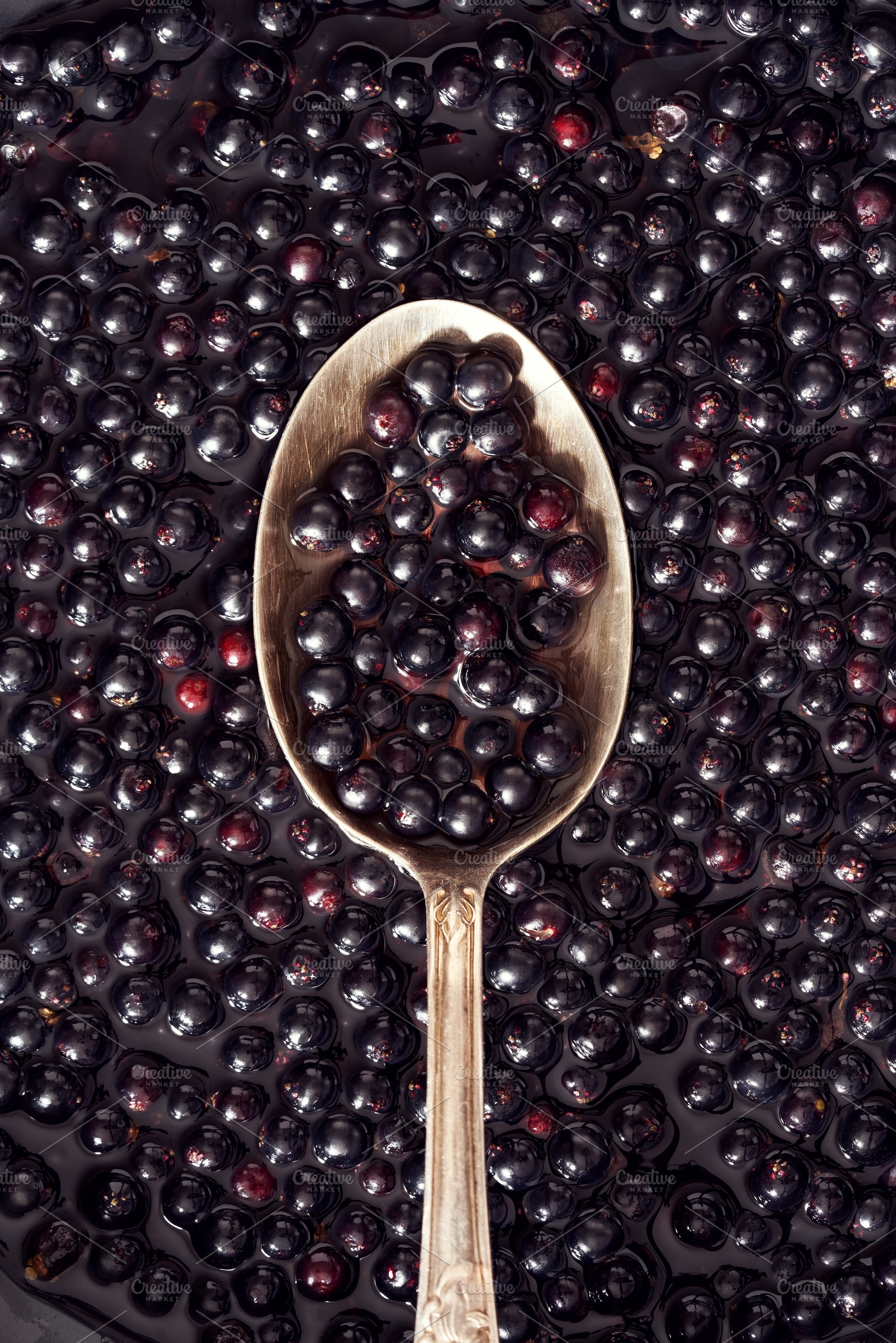 Fresh black elderberries on a metal spoon - preparation of antiv, a Food & Drink Photo by Madeleine Steinbach