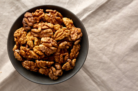 Raw Walnut Halfs in a Bowl, top view. Flat lay, overhead. Copy s