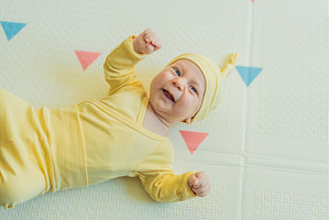 Adorable baby in a yellow hat lying, a Beauty & Fashion Photo by Elizaveta Galitskaya