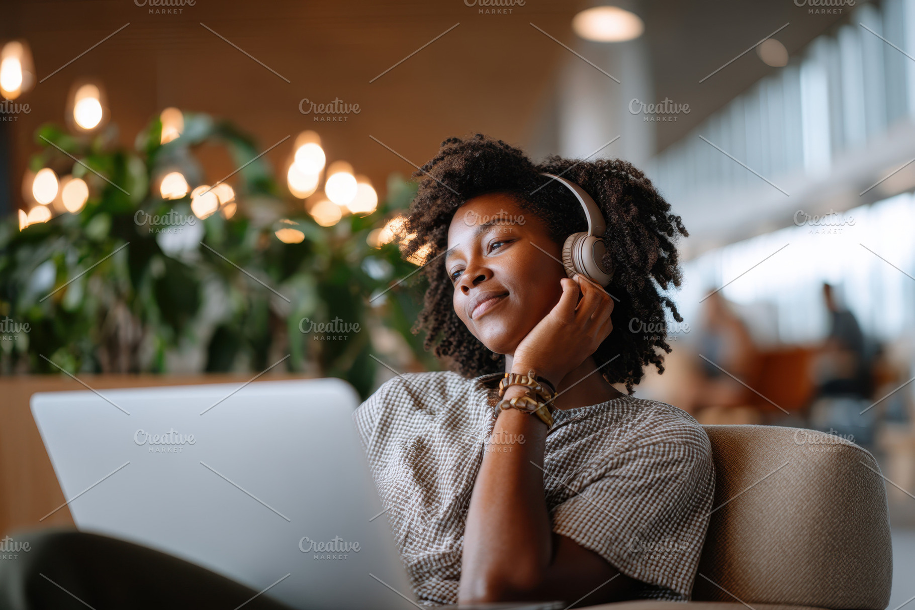 Young woman enjoying music while working on laptop, a Business Photo by AlyaAnd