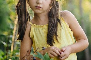 Portrait of a cute little girl standing near a blueberry bush in the garden. Ad, a Person Photo by Rohan Photography