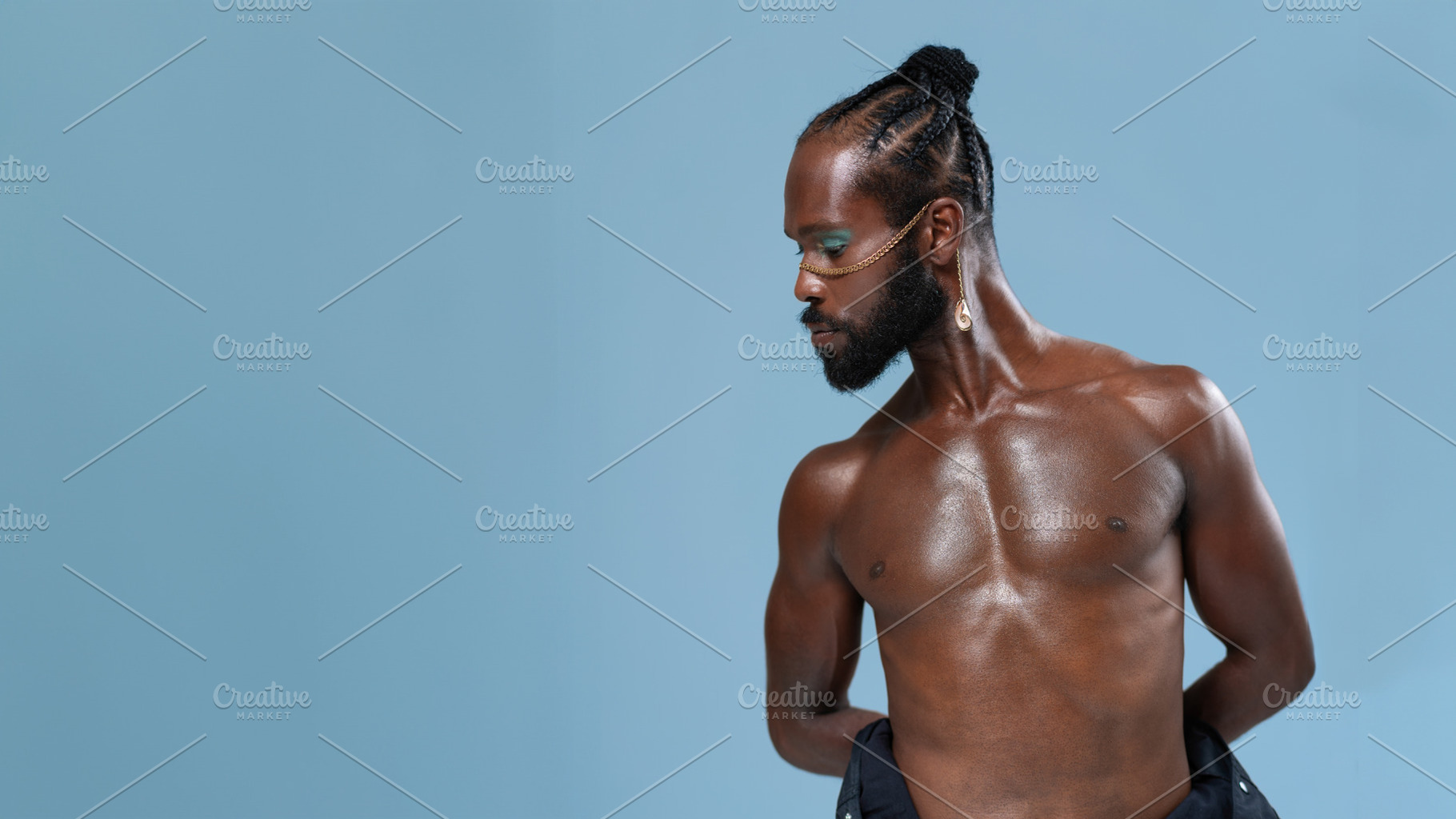 Shirtless gay model with hands behind back looking down in blue studio, a Person Photo by andreonegin market