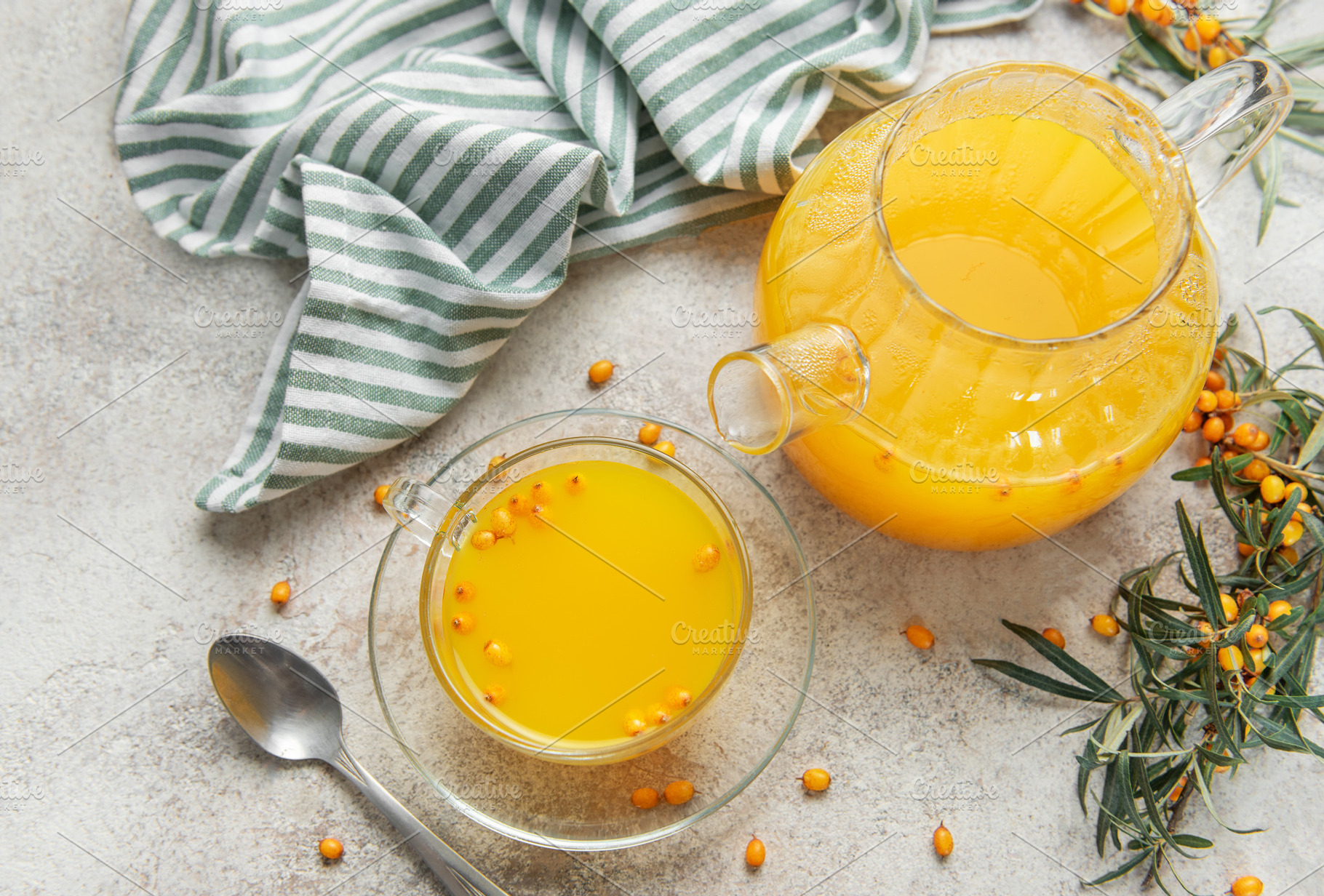 Sea buckthorn tea with fresh berries and a teapot on table, a Food & Drink Photo by Olena Rudo