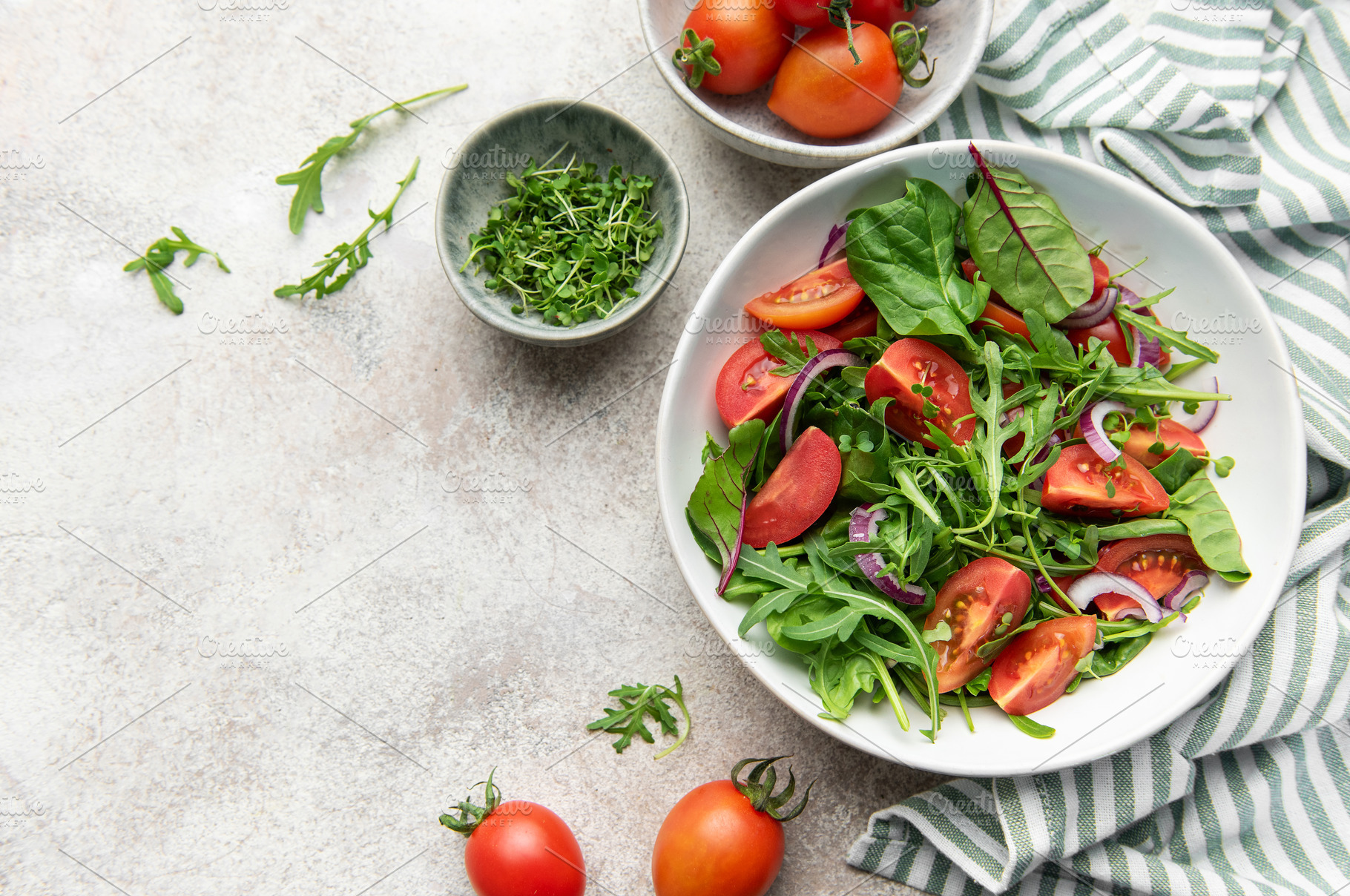 Fresh green salad with tomatoes and red onion, a Food & Drink Photo by Olena Rudo