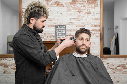 Man barber cutting hair of male client with clipper at barber shop. Hairstyling, a Person Photo by david.herraez.calzad