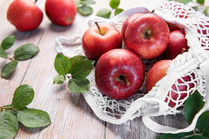 Fresh red apples resting in reusable shopping bag promoting sust, a Food & Drink Photo by Olena Rudo