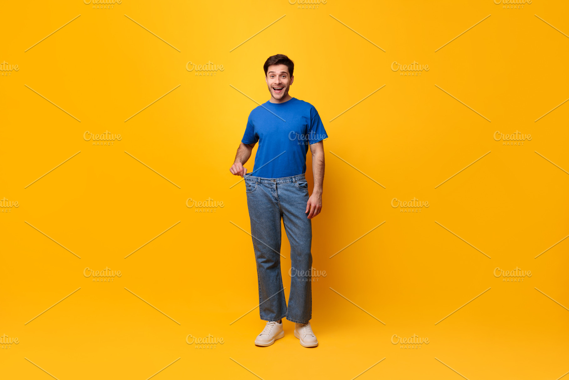 Happy Man Pulling His Old Large Loose Jeans, a Photo by Prostock-Studio