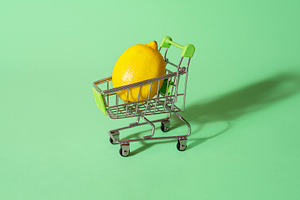 Tiny shopping cart with a lemon. Buy