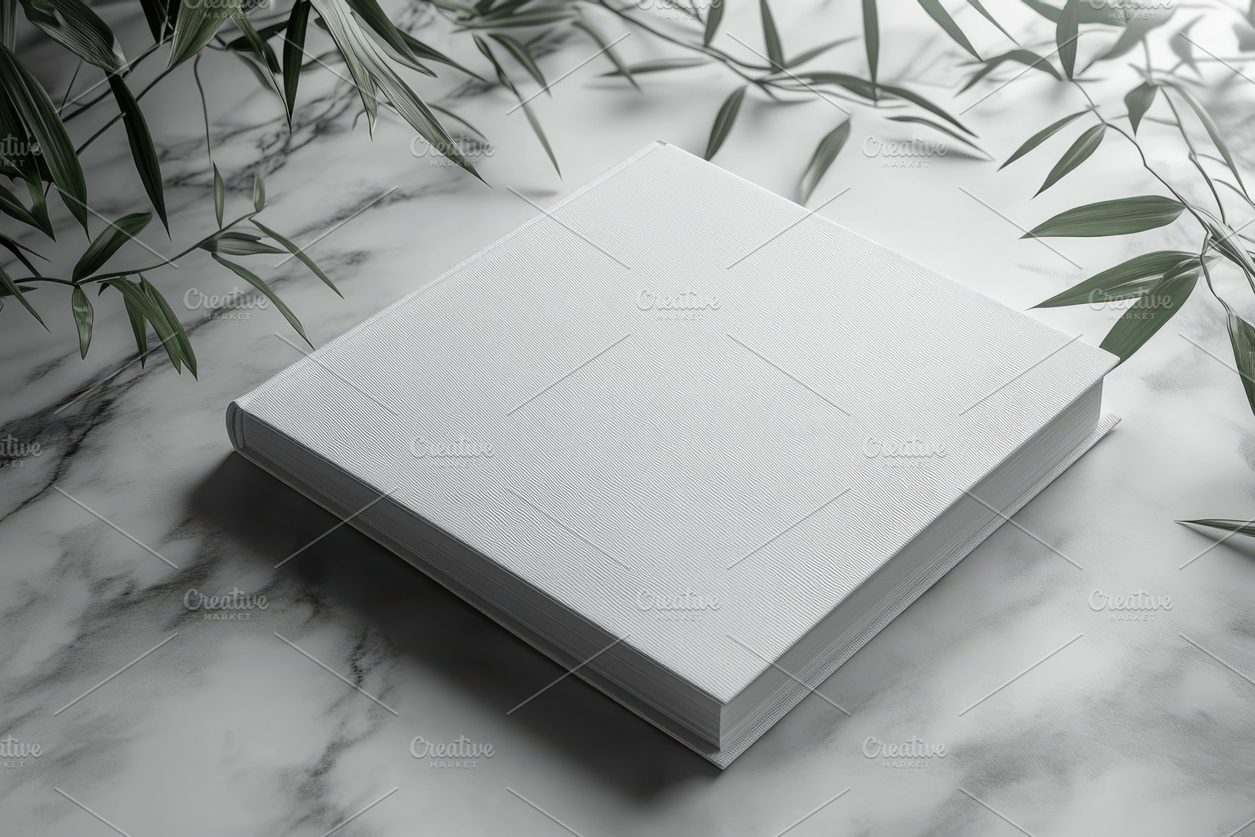 White book on marble with green leav, a Background Photo by Pixeness Studio