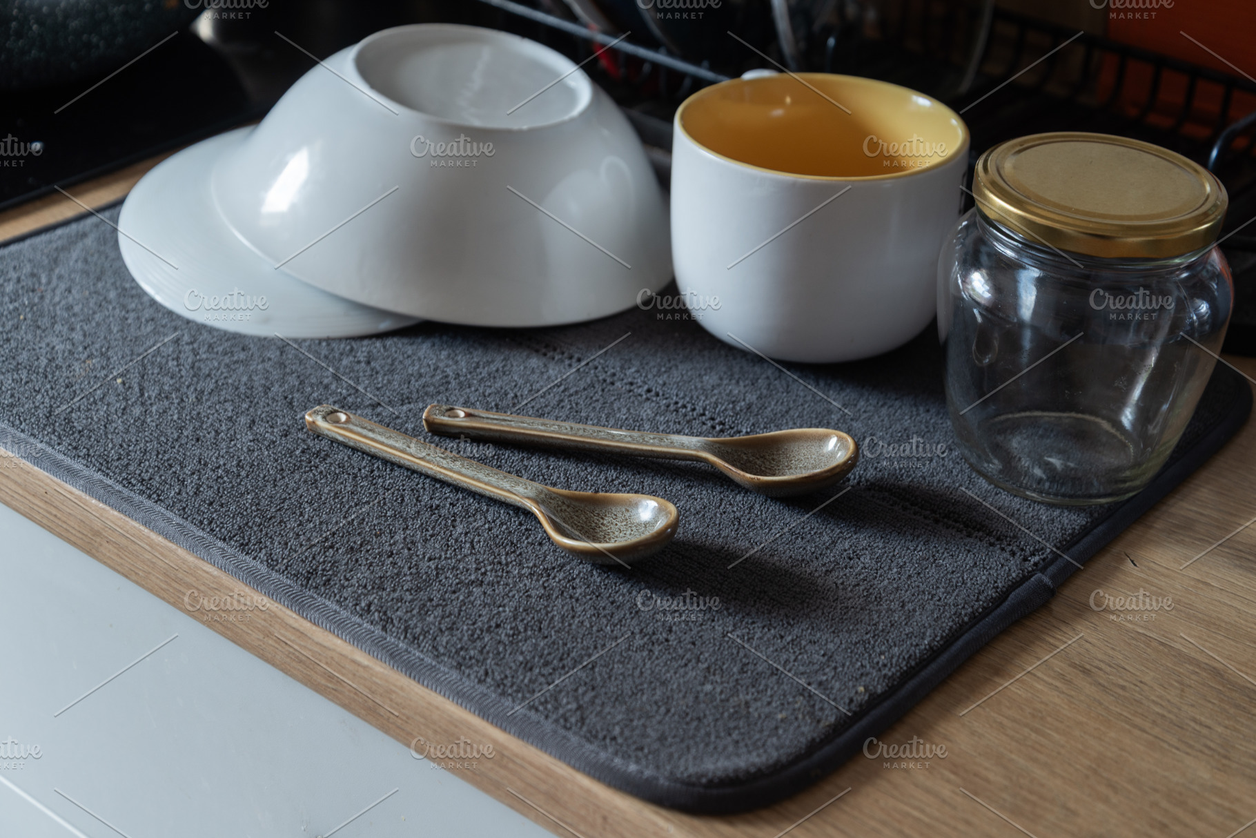 Clean washed dishes arranged on a gray drying mat on a kitchen c, an Industrial Photo by MDBildes