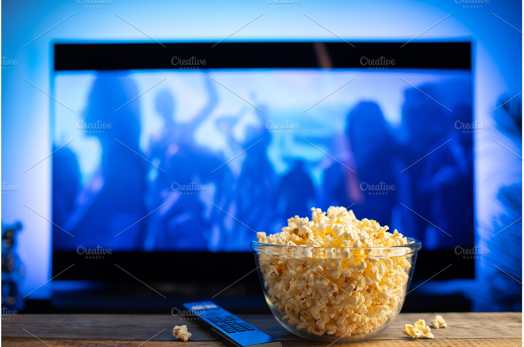 A glass bowl of popcorn and remote, a Technology Photo by Budarinphoto