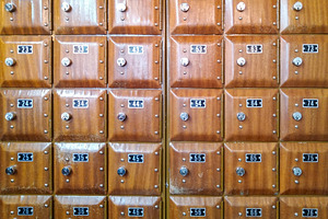 Grid of wooden mailboxes with metal locks, an Industrial Photo by DanFLCreativo