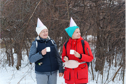 Two friends stand joyfully in a