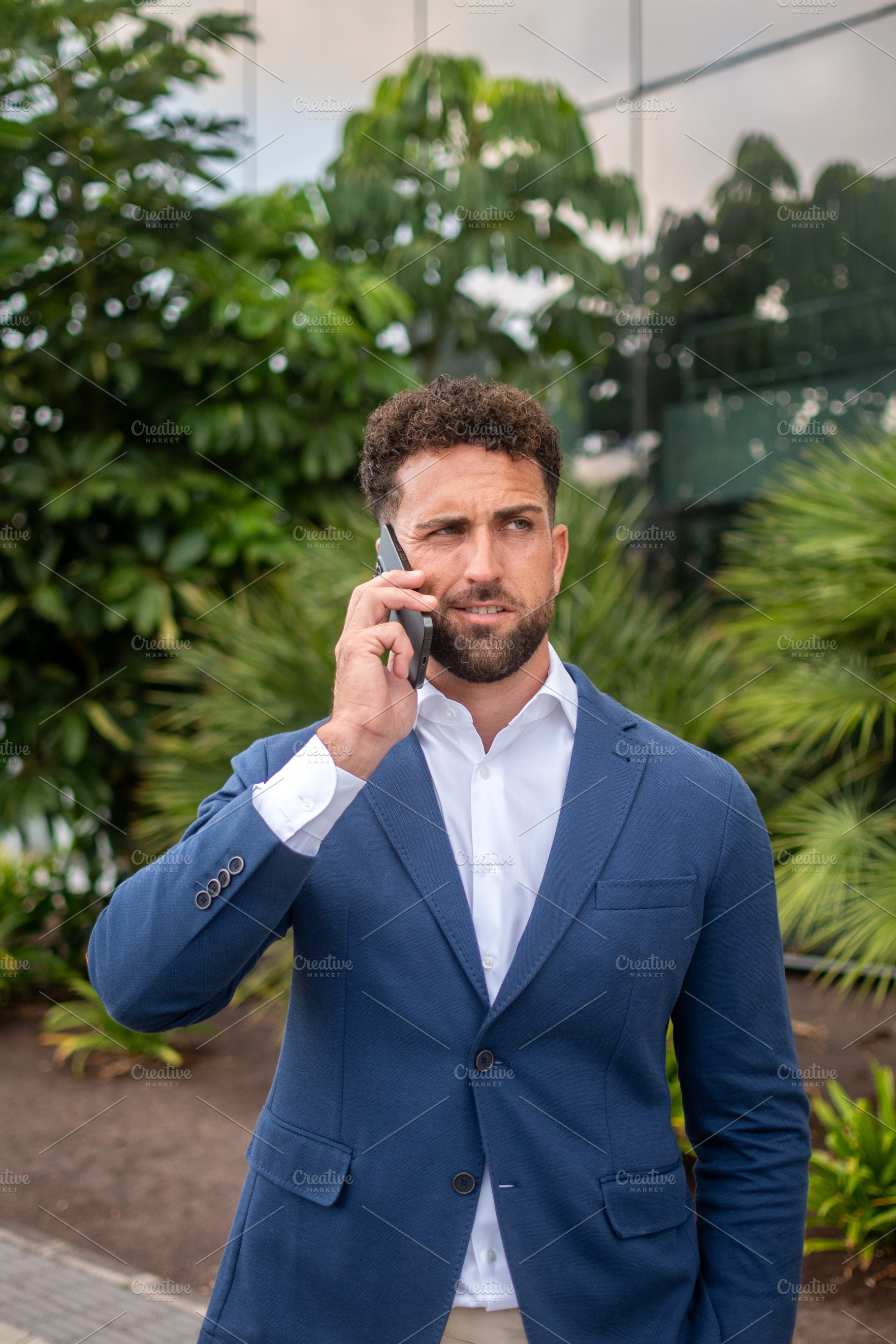 Businessman having a serious phone conversation outside office, a Business Photo by etorres69