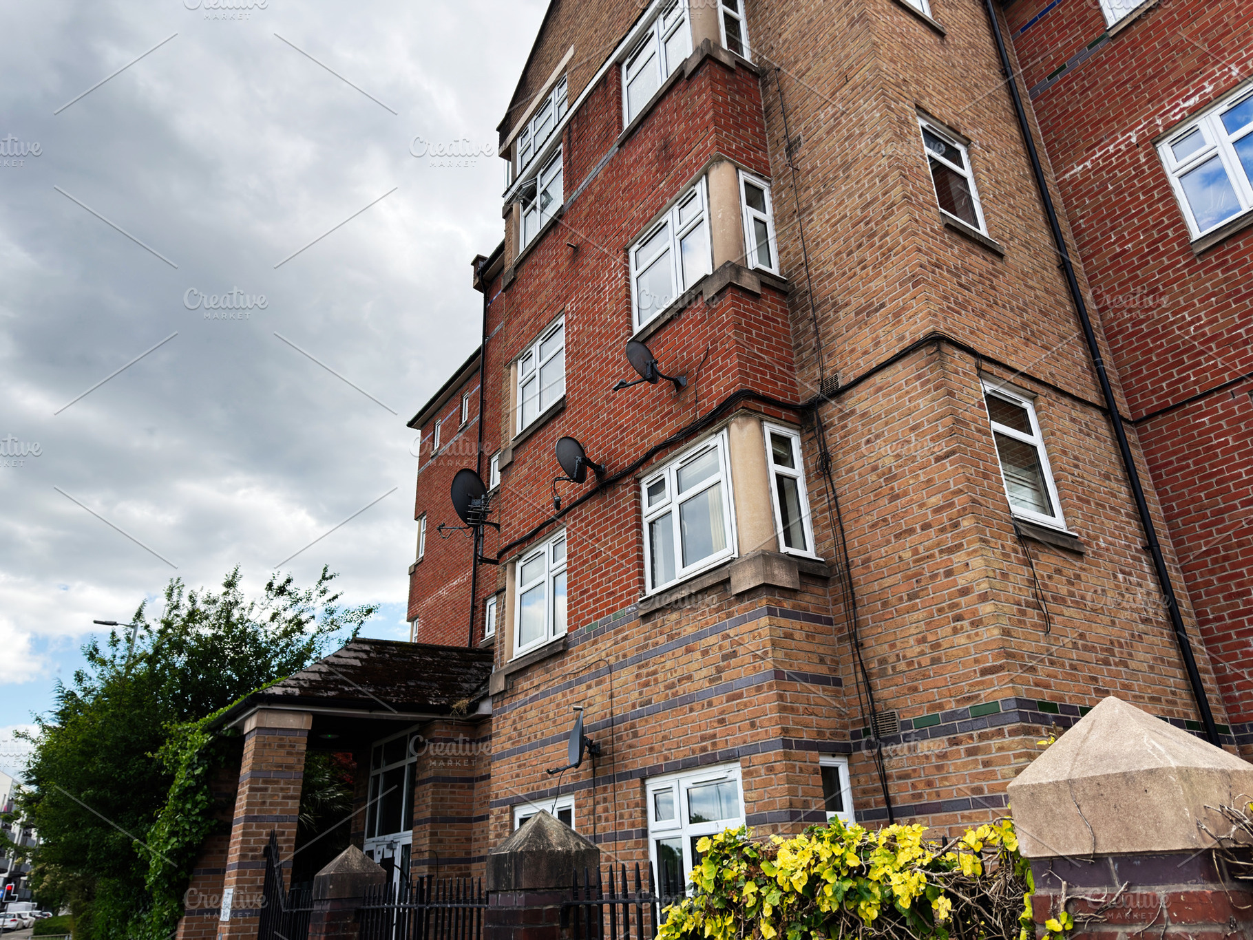 Brick apartment building with satellite dishes and bay windows u, a Photo by AS photostudio