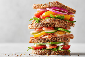 Tall stacked multigrain sandwich with fresh layers, a Food & Drink Photo by AlyaAnd