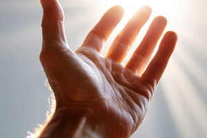 Hand reaching towards bright light, a Person Photo by AlyaAnd