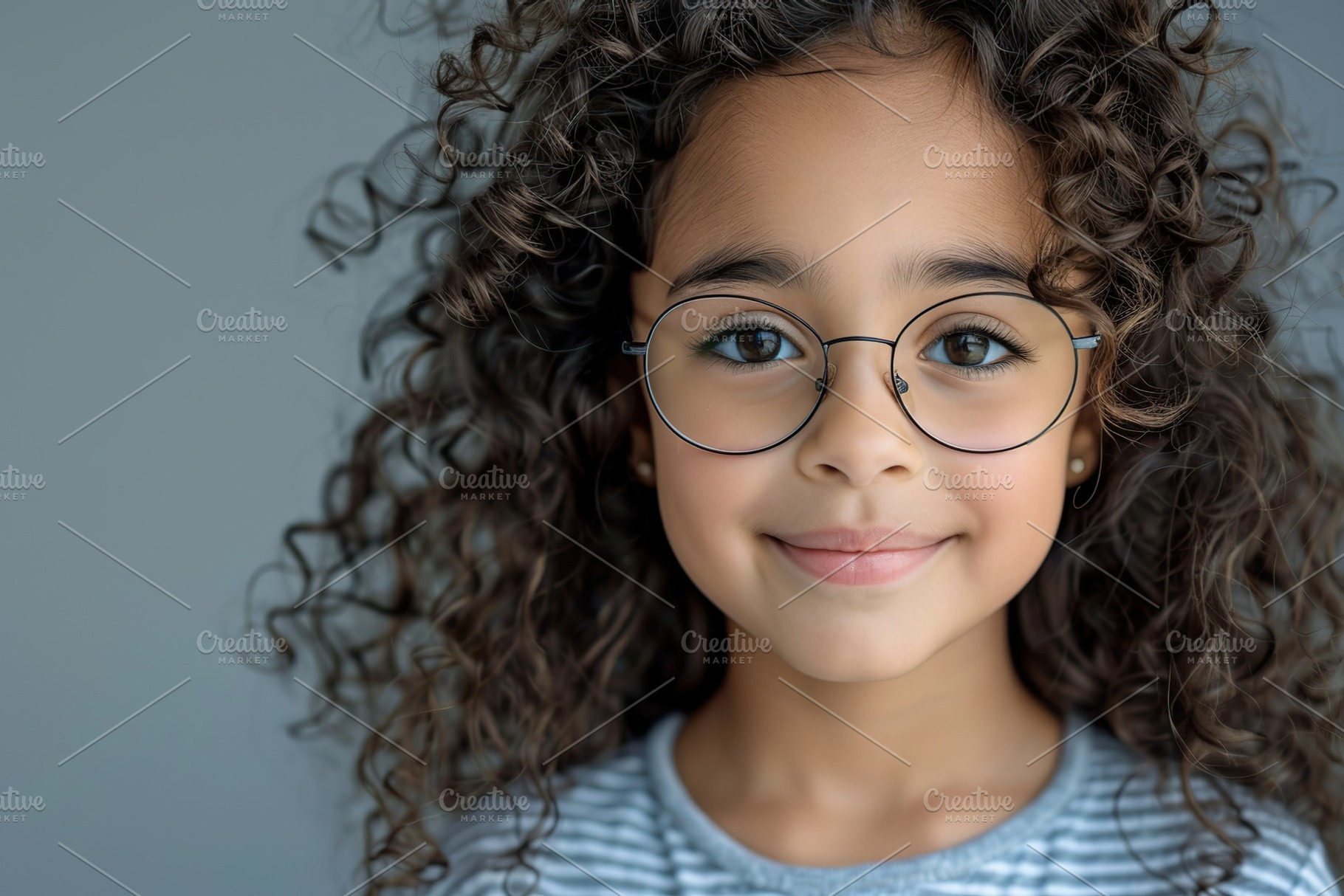 Cute little girl in eyeglasses with curly hair on grey background, a Person Photo by AlyaAnd