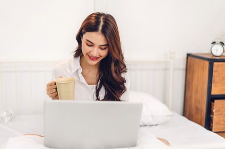 Young smiling happy beautiful asian woman relaxing using laptop, a Person Photo by Art_Photo
