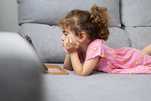 Little girl watching videos on tablet, a Person Photo by etorres69