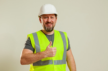 worker in a vest and white helmet, a Person Photo by Photostock
