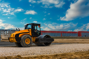 Yellow road roller compactor working on gravel at a construction, a Transportation Photo by Ales Munt