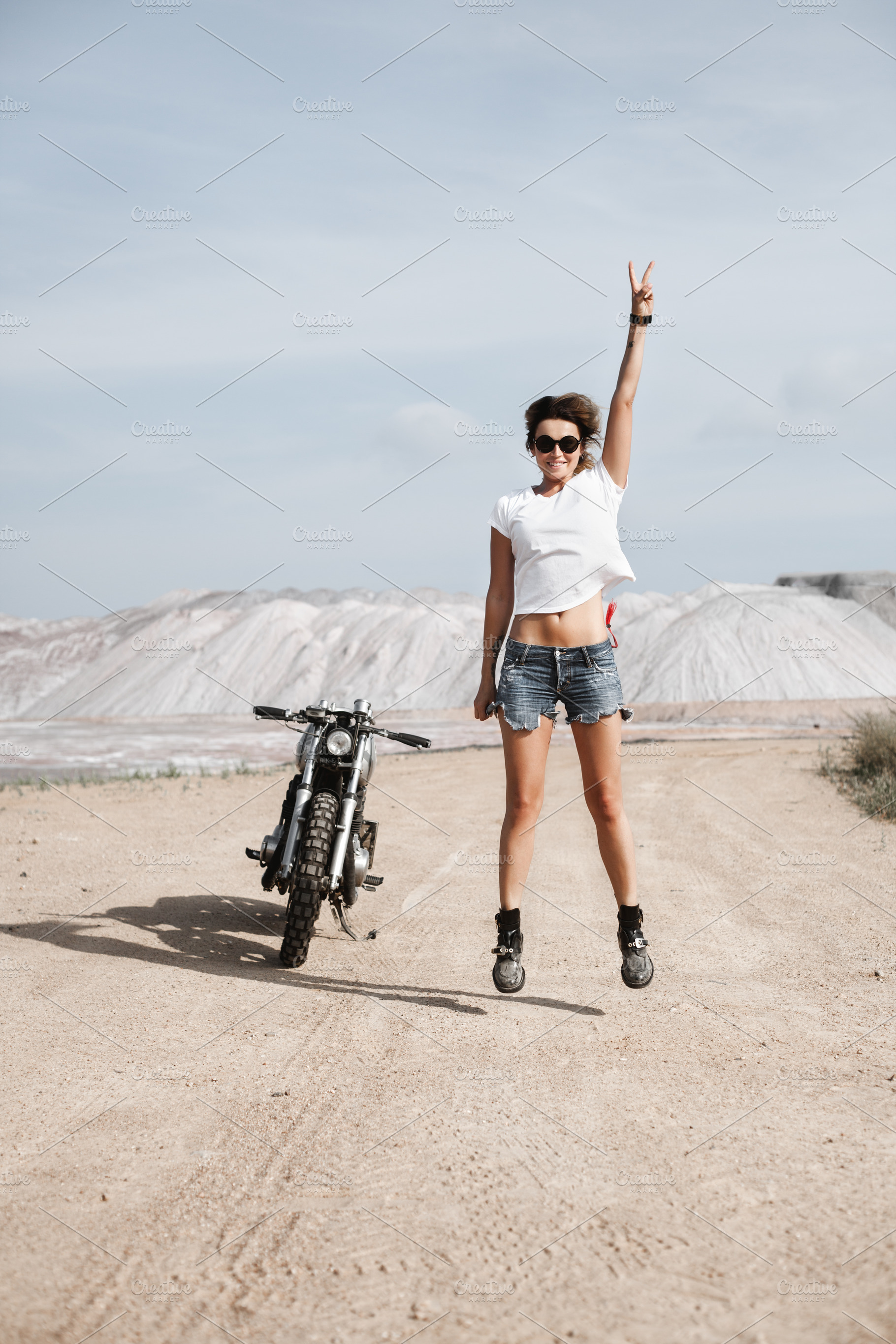 Sexy girl biker and cafe racer motorcycle containing wheels, motorcyclist, a Person Photo by Aliaksei Kaponia