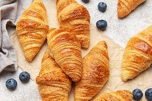 Freshly baked croissants with honey, blueberries, and milk for b, a Food & Drink Photo by Olena Rudo