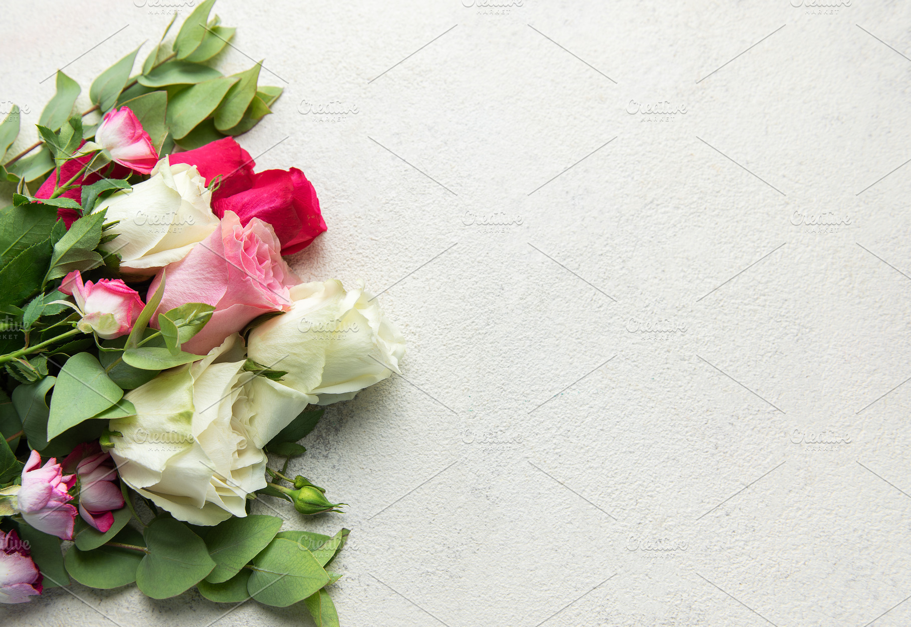Roses bouquet with eucalyptus leaves on concrete background, a Holiday Photo by Olena Rudo