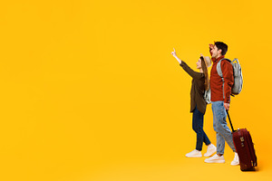 Travelers Couple Pointing Finger Looking Aside At Copy Space, Studio, a Photo by Prostock-Studio