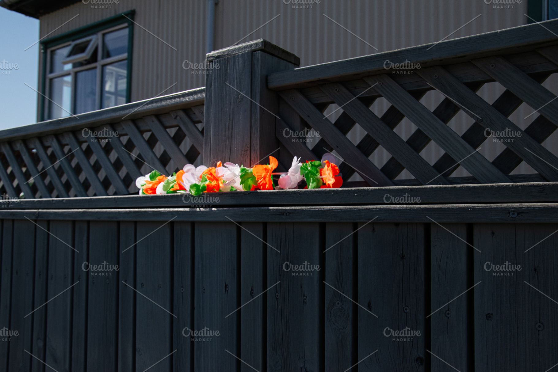 Lattice fence with Irish-themed decoration under sunlight in Akranes, Iceland, a Photo by AS photostudio