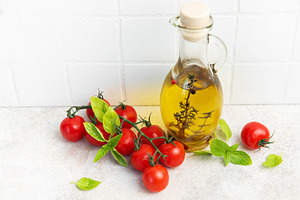 Olive oil bottle with fresh cherry tomatoes basil, a Food & Drink Photo by Olena Rudo