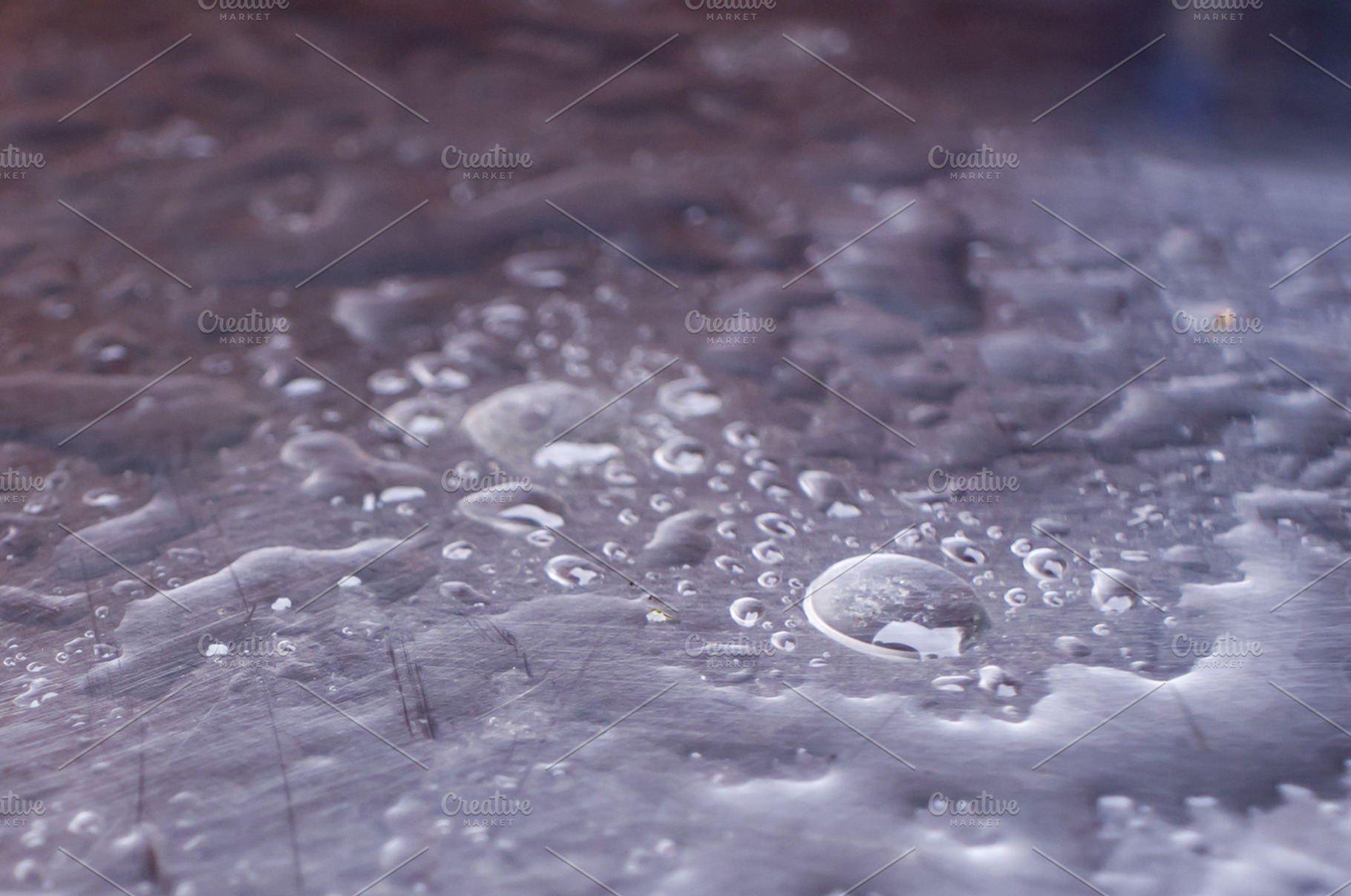 Shiny metal surface with water drops