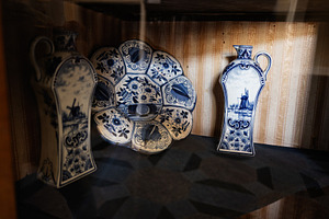 Antique blue white porcelain pieces with intricate floral and windmill designs, a Photo by AS photostudio