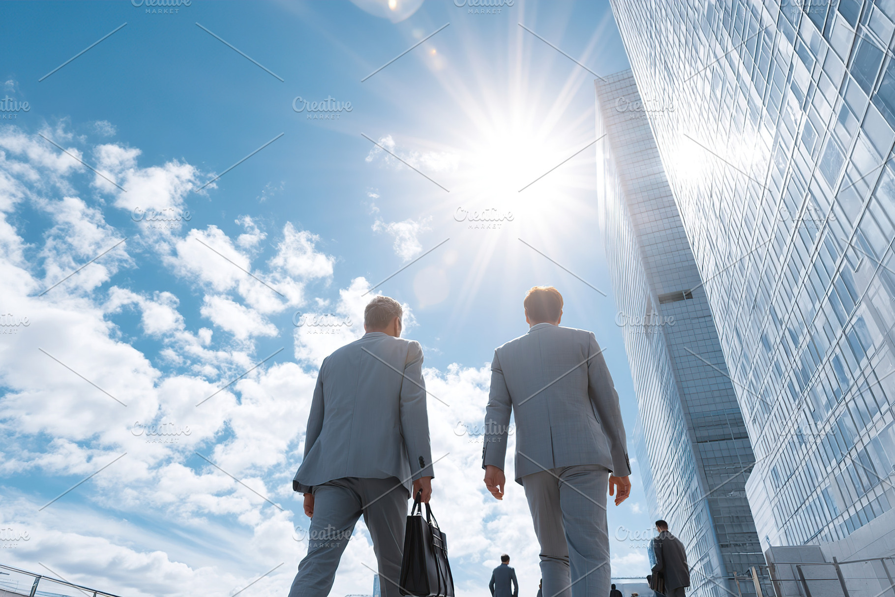 Business professionals walking towards a modern skyscraper under bright sunligh, an Architecture Photo by AlyaAnd