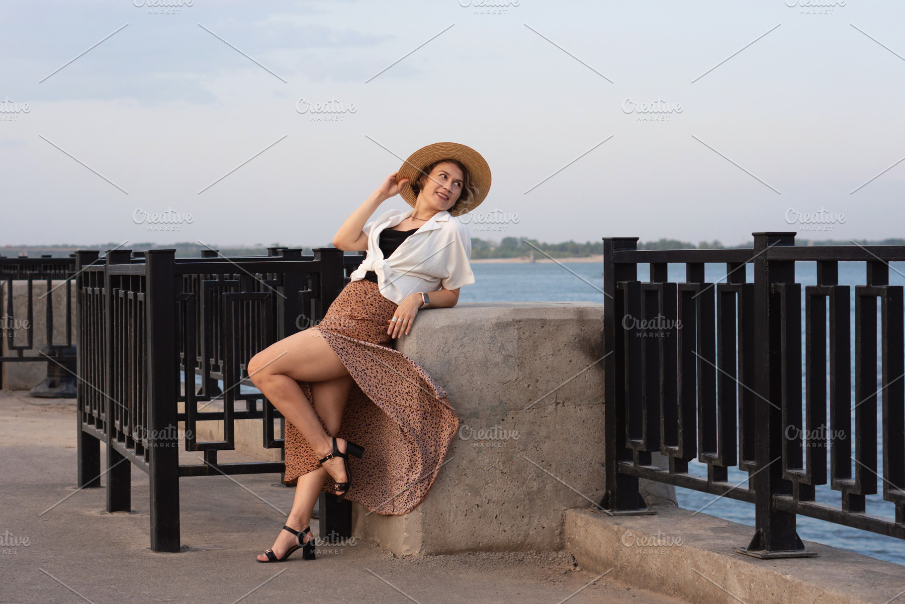 Smiling woman reclines on river wall, a Person Photo by Elena Vagengeim