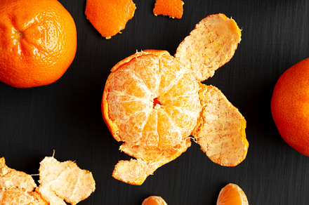 Raw Organic Mandarin Oranges on a black surface, top view. Flat, a Food & Drink Photo by LiudmylaChuhunova