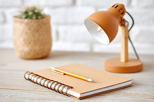 Workspace featuring an analog notepad and e-ink technology next to a stylish la, a Photo by AlyaAnd