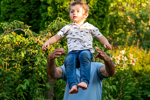 Grandfather playfully lifting boy, a Person Photo by Elena Vagengeim