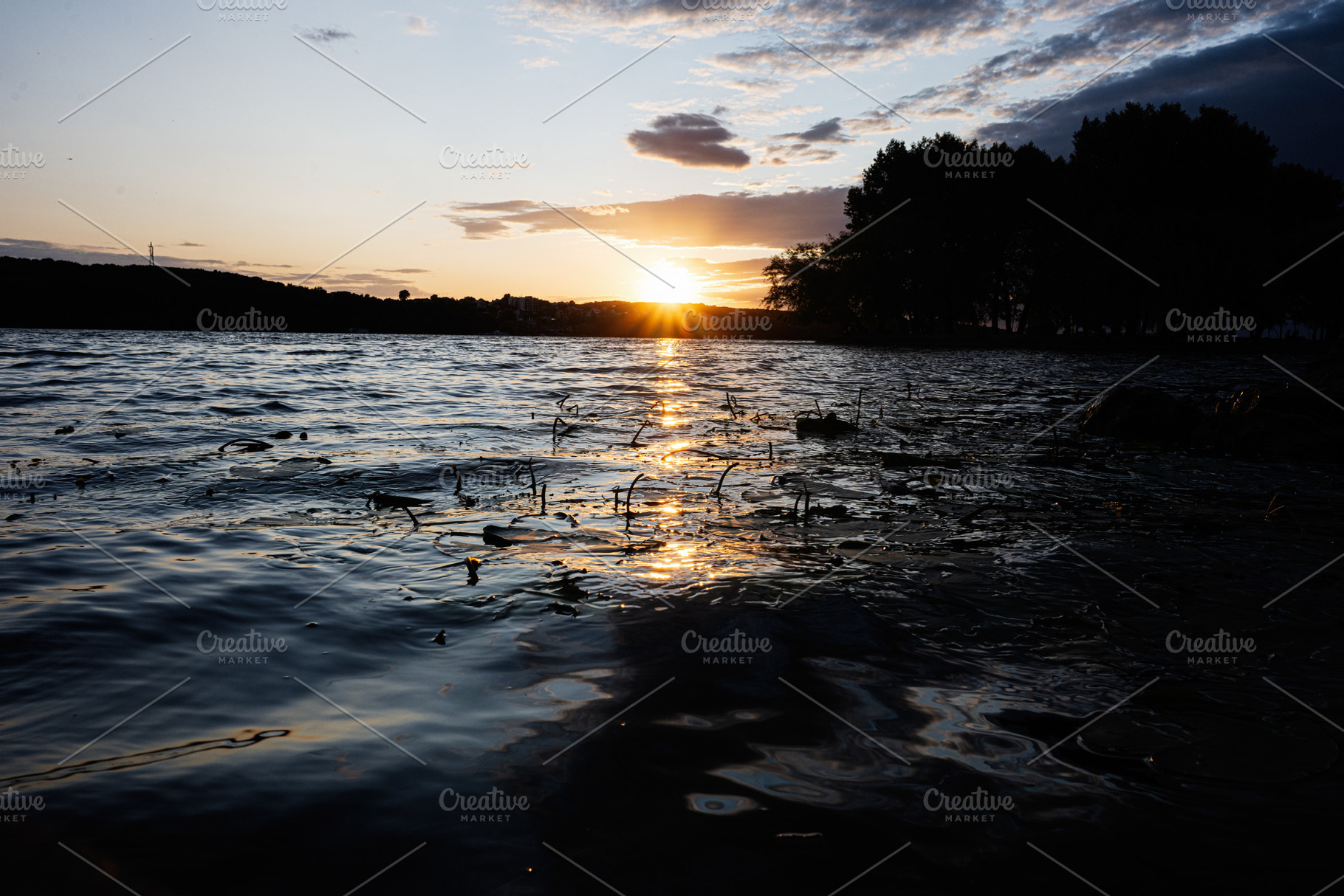 Sunset view over calm lake surrounded by silhouetted trees and serene reflectio, a Photo by AS photostudio